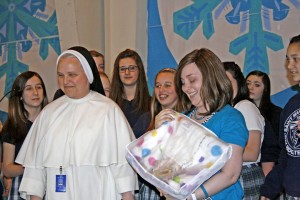 Teacher Darlene Adams holds a prayer blanket presented to her by Sister Marie Blanchette Cummings, OP, and students in the Challenge youth group at St. Mary in Oak Ridge. Photo by Dan McWilliams