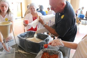 Parishioners from across the Diocese of Knoxville gather together July 25 at St. Thomas the Apostle Church to fill food bags that will go to feed people in the African country Burkina Faso. The mission program was led by Catholic Relief Services and Helping Hands. Photo by Bill Brewer 