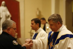 Knoxville Police Officer Gary Holliday receives communion from Bishop Richard F. Stika at the diocesan Blue Mass Feb. 8 at Sacred Heart Cathedral. Photo by Bill Brewer