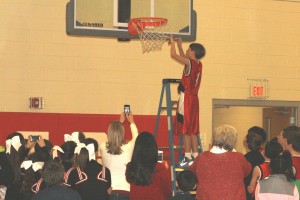 St. Joseph point guard Luke Smith, the KISL small school division tournament MVP, takes a turn cutting the net after he led the Bulldogs to a tournament championship victory over St. Mary School of Oak Ridge on Feb. 5 at St. Joseph. Photo by Bill Brewer