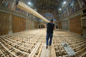 A worker carries in timber March 6 as the Vatican's Sistine Chapel is prepared for the conclave. A temporary floor was being installed so that it is level with the stepped altar area. Photo by CNS photo/L'Osservatore Romano
