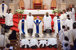 THE DIOCESE'S NEWEST DEACONS Julian Cardona, Adam Kane, Tony Budnick, and Colin Blatchford prostrate themselves before the altar during the Litany of the Saints in their diaconal ordination Mass on June 22 at Sacred Heart Cathedral. Bishop Richard F. Stika kneels in front of the four and is joined by priests, deacons, and diocesan seminarians, who served at the altar during the Mass. Photo by Stephanie Richer
