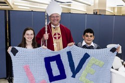 CONFIRMATION PROJECT Our Lady of Fatima Parish confirmandi Allison Gentry and A. J. Palermo ask Bishop Richard F. Stika’s blessing on their class’ service project, a prayer shawl to be donated to the diocesan Rachel’s Vineyard ministry. Photo by Roy Ehman