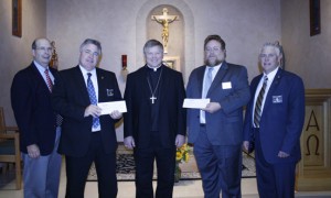 Making the check presentations to Bishop Richard F. Stika are, from left, Mike Wills, Hank McCormick, Tracy Staller, and Ron Henry. Photo by Dan McWilliams