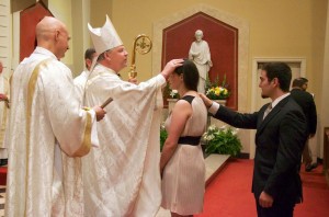 Bishop Richard F. Stika blesses a new member of the Catholic Church during Easter Vigil April 19 at Sacred Heart Cathedral Photo by Scott Maentz