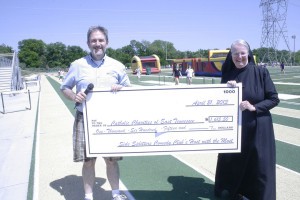 Sister Mary Christine Cremin, RSM, and Knoxville radio personality Frank Murphy display some of the funds raised for the 16th annual Kids Helping Kids Fun Walk to benefit Catholic Charities of East Tennessee's Columbus Home. Photo by Dan McWilliams