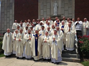 Bishop Richard F. Stika, center front row, stands between newly ordained priests, from left, Father Tony Budnick, Father Colin Blatchford, Father Julian Cardona, and Father Adam Kane. They are surrounded by priests and deacons attending their ordination Mass May 31. Photo by Bill Brewer 