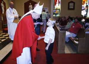 Bishop Richard F. Stika greets one of the newest members of the diocese, fifth-grader Canyon Garren of St. Thomas the Apostle Church in Lenoir City. Photo by Bill Brewer