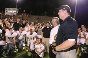 Bishop Richard F. Stika presents the Irish Bowl Trophy to Knoxville Catholic High School football coach Steve Matthews following the Fighting Irish's 15-12 win over Notre Dame High School on Aug. 22. Photo by Bill Brewer
