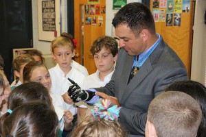 Retired Army Staff Sgt. Leroy Petry demonstrates his artificial hand to students at Sacred Heart Cathedral School on Sept. 12 as part of a ceremony honoring Medal of Honor recipients. Photo by Dan McWilliams