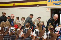 HEROES WELCOME Sacred Heart Cathedral School students who are in the Scouts salute Medal of Honor recipients Leroy Petry, center, and Ty Carter, right, as the veterans visit the school on Sept. 12. Army Staff Sgt. (Retired) Petry and Army Specialist Carter were among nearly 50 Medal of Honor veterans attending a convention in Knoxville. Walking with the veterans are Cardinal Justin Rigali and Father Arthur Torres Barona.  Photo by Scott Maentz