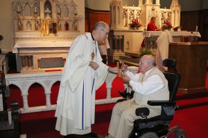 Father Jerry Tully, CSP, gives Communion to Judge Charles Susano at the annual Red Mass, celebrated by Bishop Richard F. Stika. Photo by Dan McWilliams