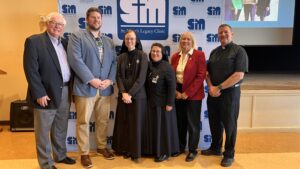 Six people standing in front of SMLC logo